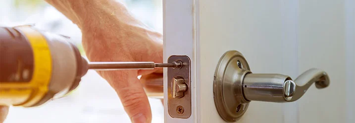 Person montiert Türklinke mit Akkuschrauber